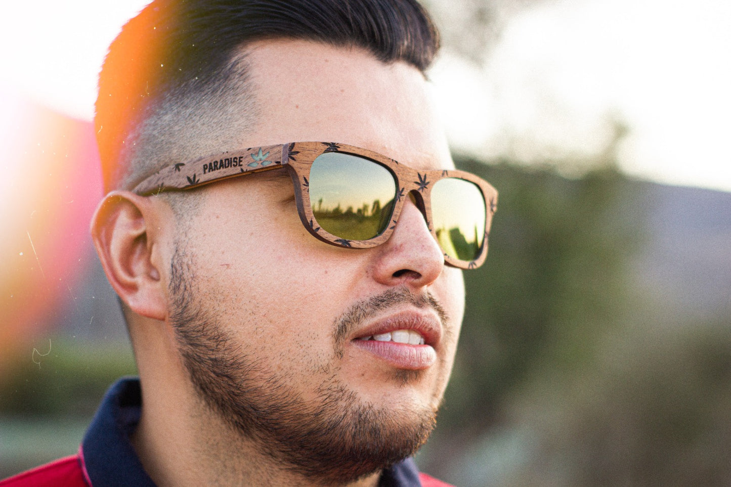 Modelo hombre usando lentes paradise de Bang, micas verdes, grabado de cannabis, fondo de vegetación