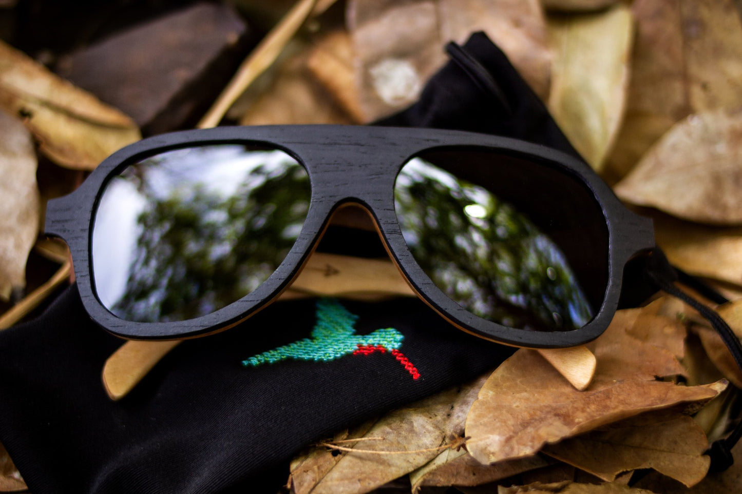 Lentes de madera de sol, modelo quetzal, marca bang, micas polarizadas, lentes de gota, lentes de aviador, fondo blanco, foto real sobre hojas secas