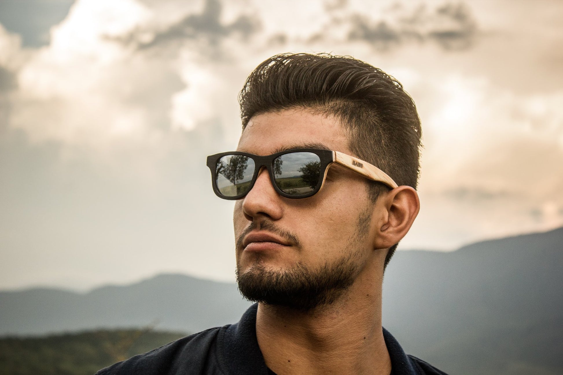 Modelo hombre con lentes de madera Bang, modelo nativo ébano, fondo de naturaleza