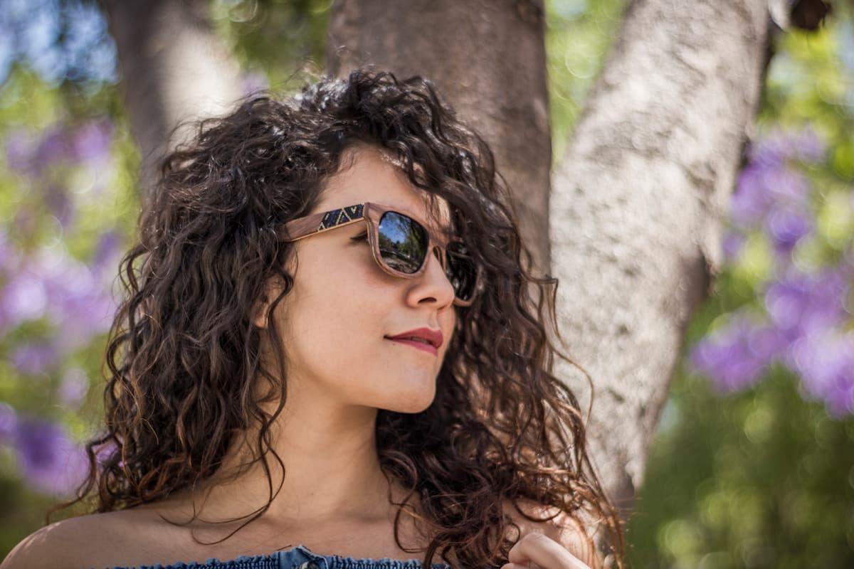Modelo mujer usando lentes de sol Bang, modelo nébula, micas polarizadas oscuras, lentes huicholes