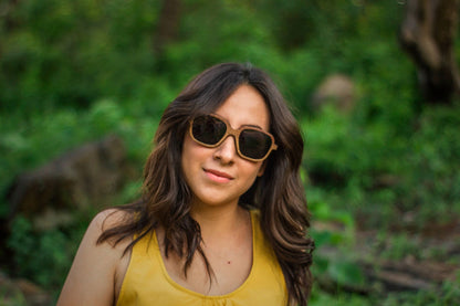 Modelo mujer usando lentes de madera Bang, modelo tulum, micas solares, fondo de naturaleza
