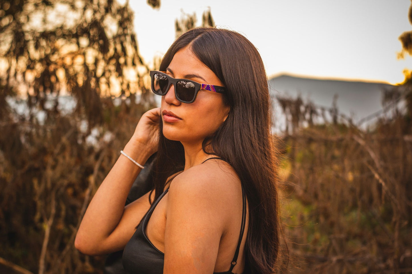 Modelo mujer usando lentes huicholes bang, modelo lluvia, intervenidos con chaquieras, lentes oscuros