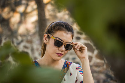 Modelo mujer usando lentes wirra bang, modelo primavera, madera nogal, intervenidos con artesanía huichol